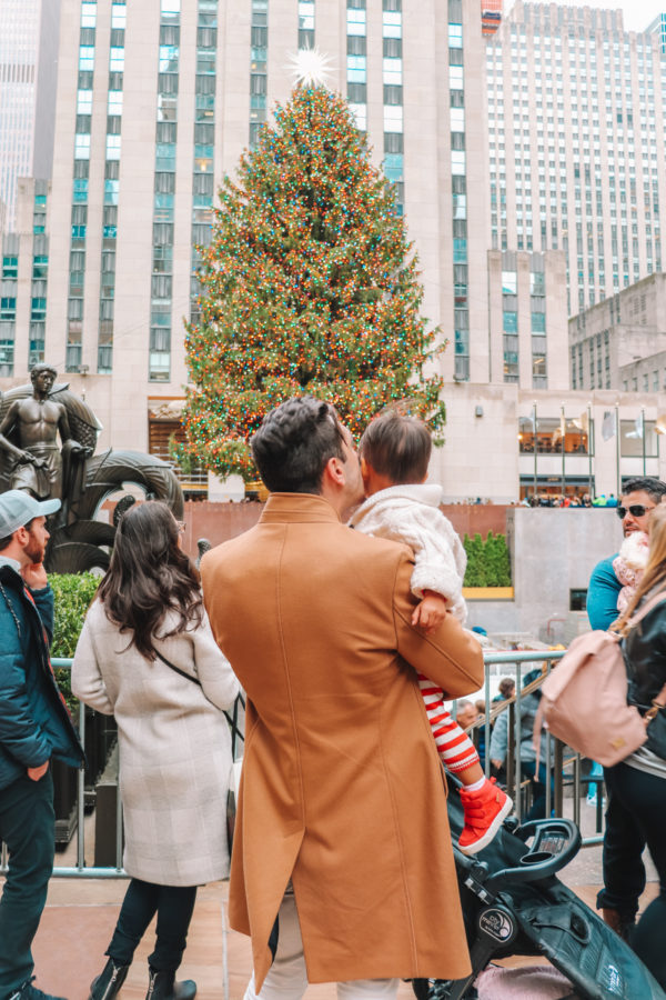 Two people in front of a Christmas tree