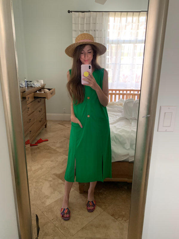 A woman standing in front of a mirror posing for the camera, with Straw Hat