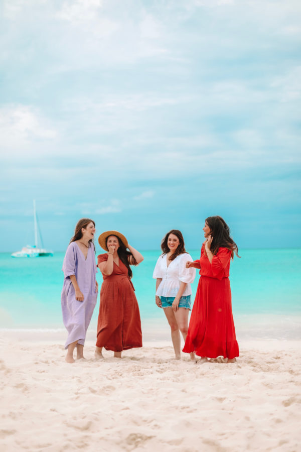 A group of people standing on a sandy beach