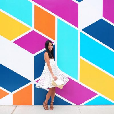 A woman in front of a colorful wall