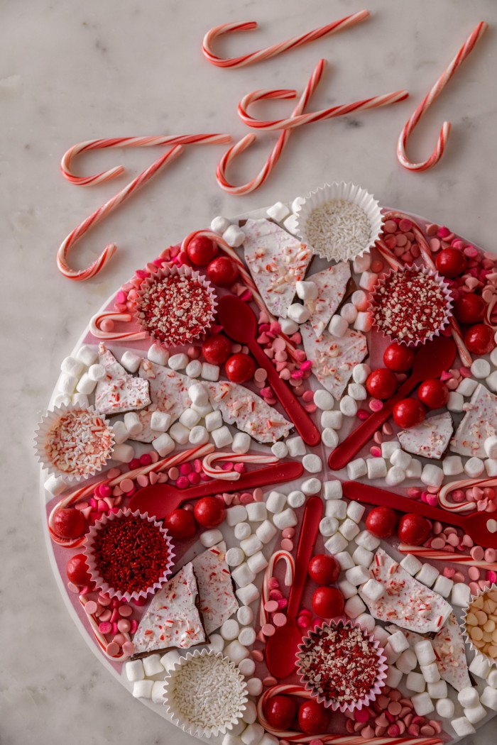 Overhead shot of a hot chocolate board with red and white hot chocolate toppings. 