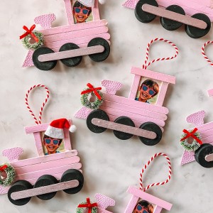 Popsicle stick train Christmas ornaments on marble table