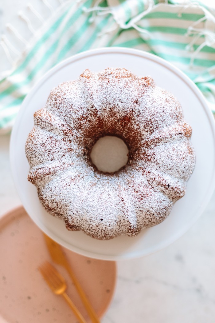 Coffee bundt cake with powdered sugar on cake stand