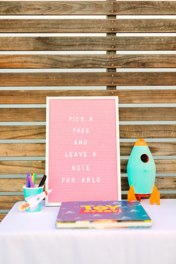 A pink sign with a rocket next to it