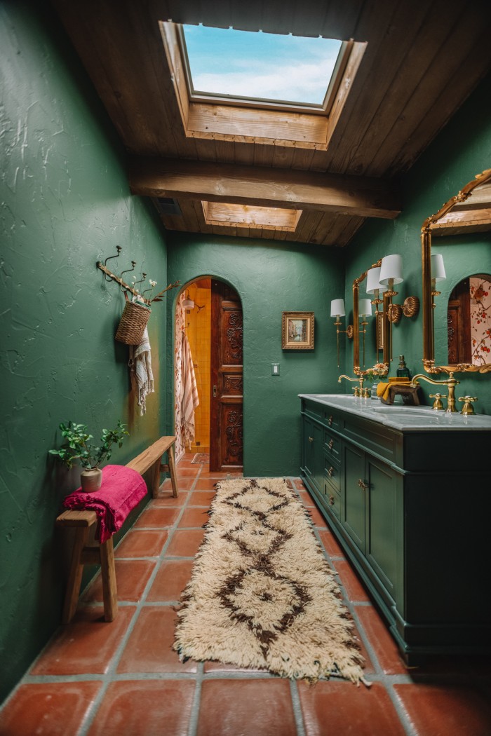 dark green bathroom with yellow shower seen through archway