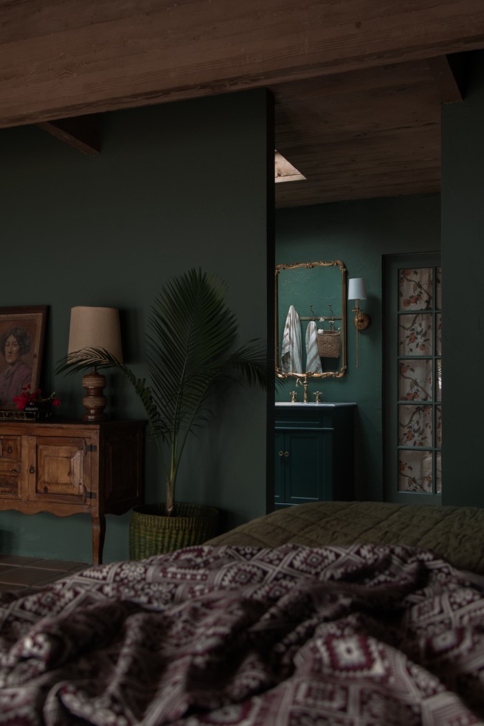 dark green bedroom looking into green bathroom