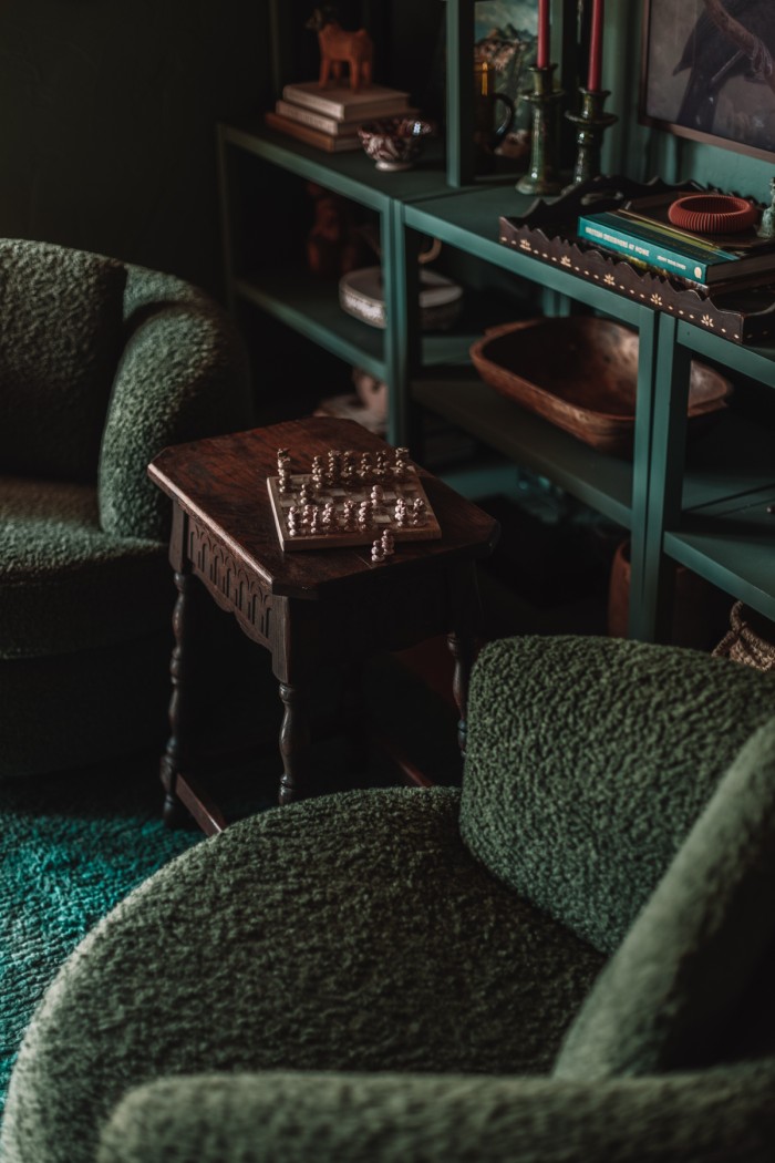 green chairs with wood table and marble chess set