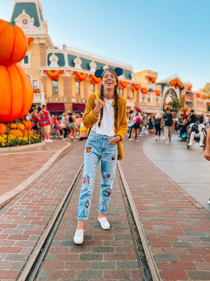 Woman in Disney patch jeans at Disneyland during Halloween
