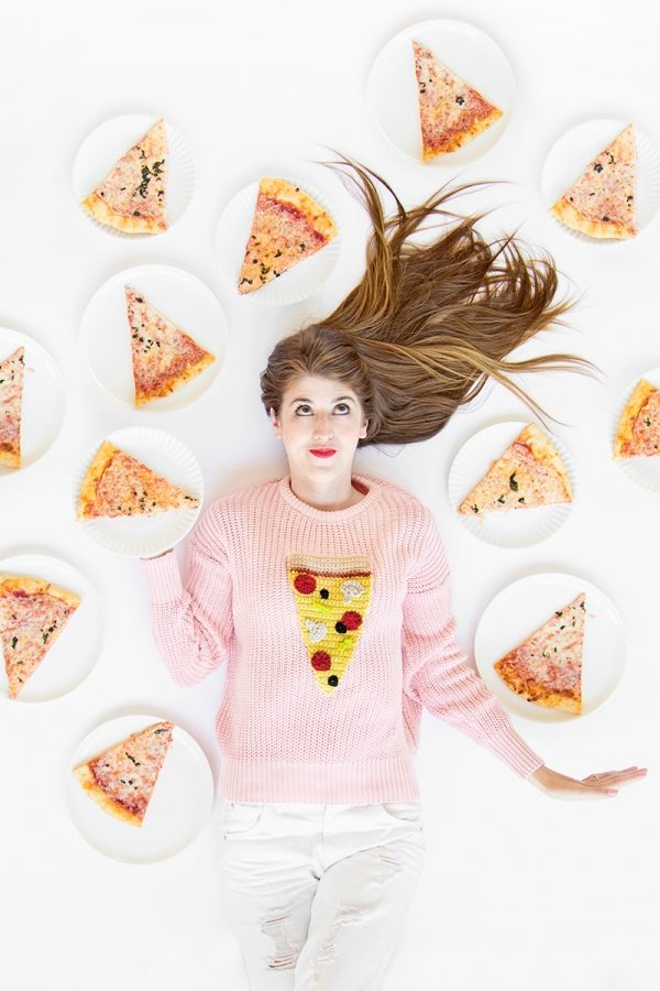 A person laying next to pizza