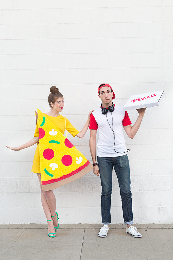 A woman dressed up as a pizza next to a man dressed up as delivery man