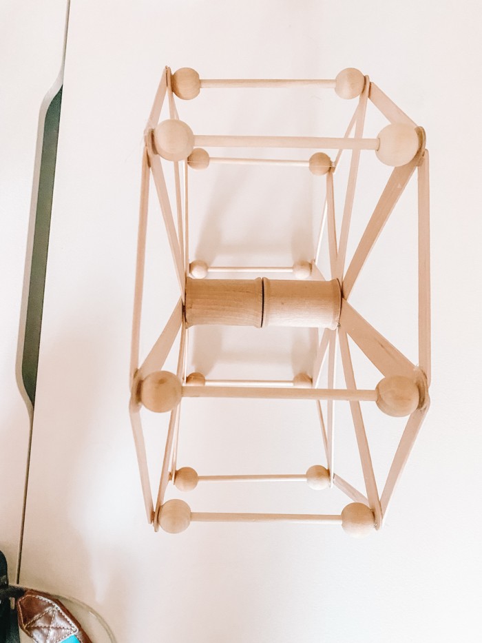 Wooden dowels and beads glued to popsicle sticks to form a ferris wheel