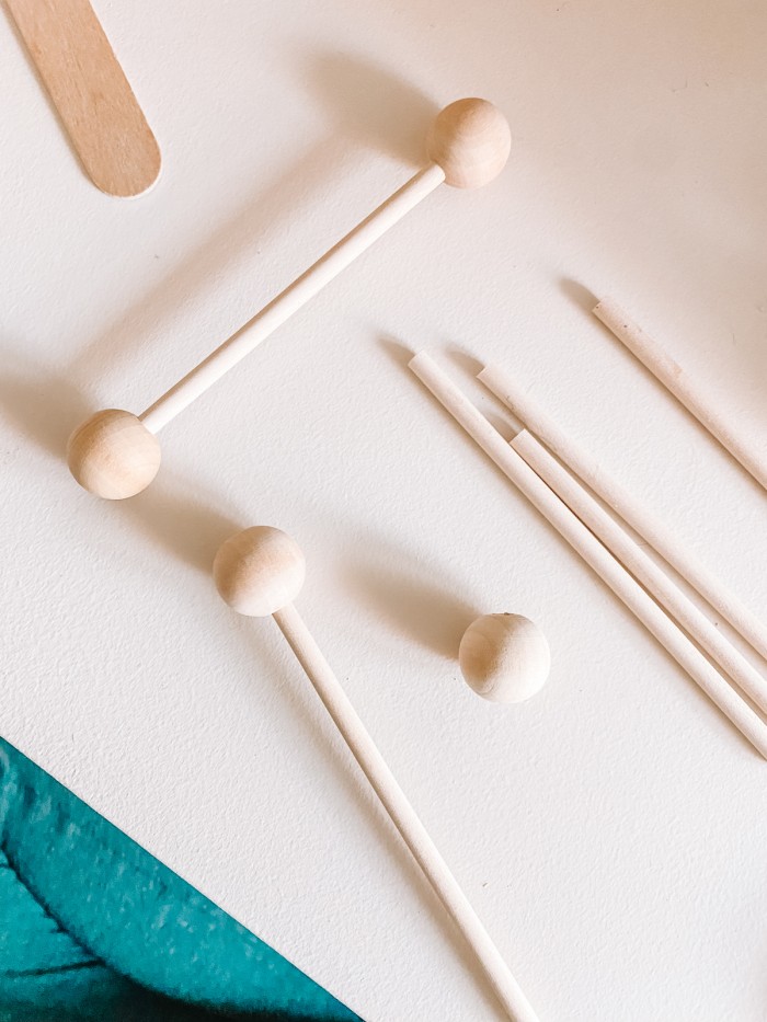 Wooden dowels and beads sitting on a white table