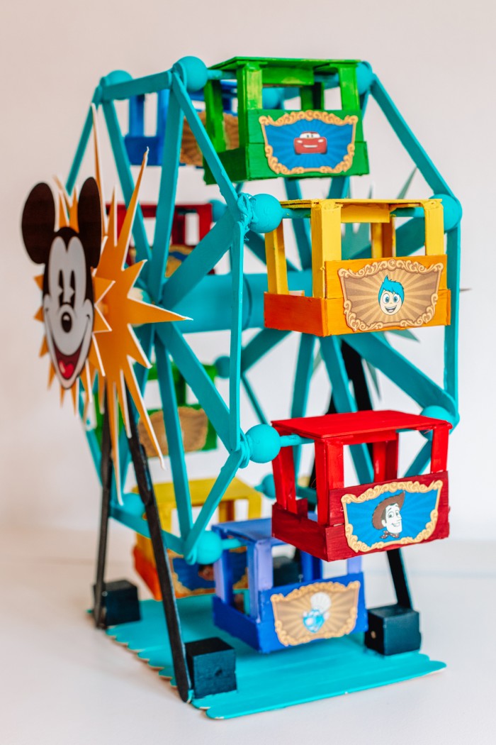 Popsicle stick Ferris wheel decorated like the Pixar Pal-A-Round from Disney's California Adventure on a white table