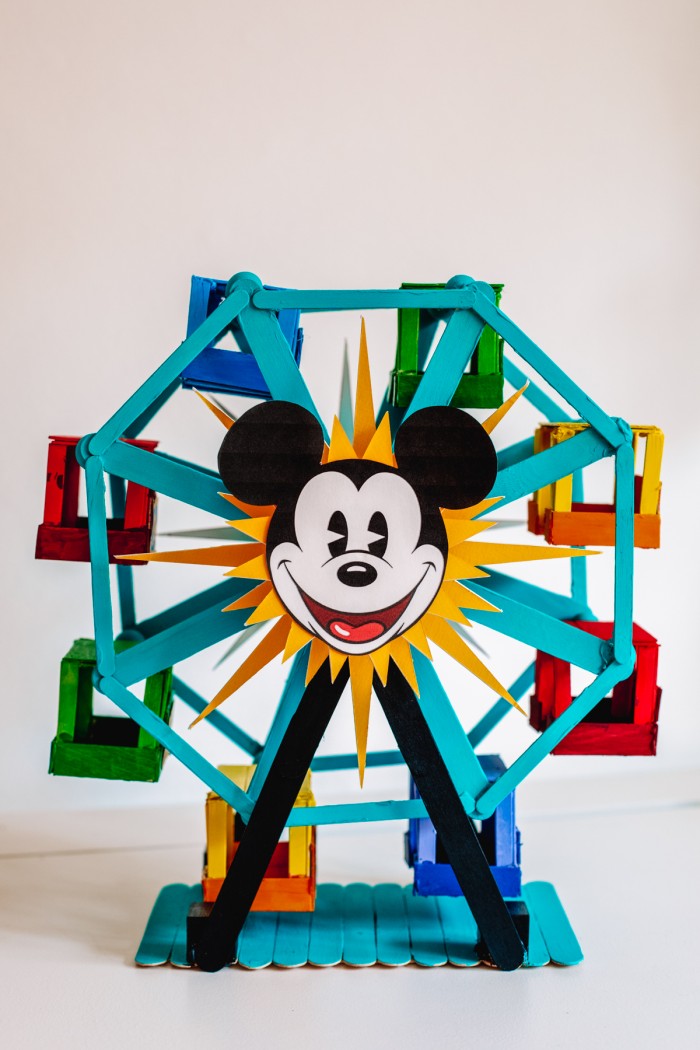 Popsicle stick Ferris wheel decorated like the Pixar Pal-A-Round from Disney's California Adventure on a white table