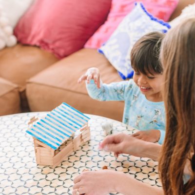 A small child playing with popsicle sticks