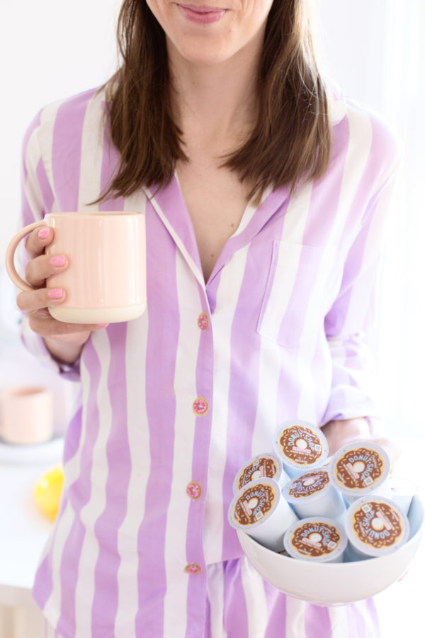 A person holding a cup and creamers