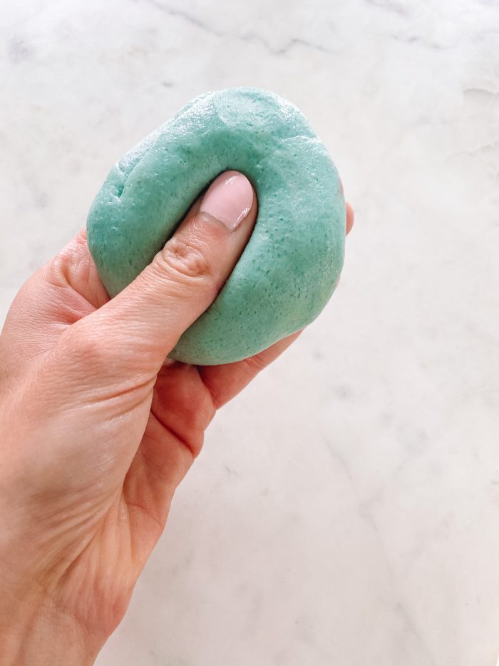 A close up of a hand holding play dough