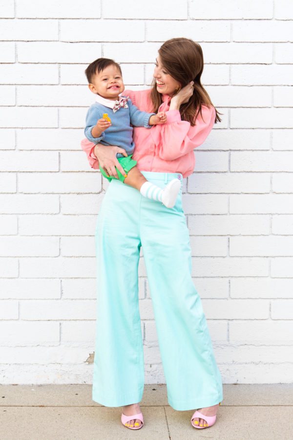 Two people standing in front of a white brick wall