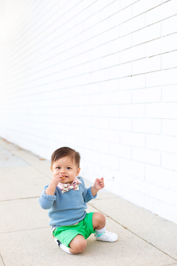 A small child sitting on a sidewalk