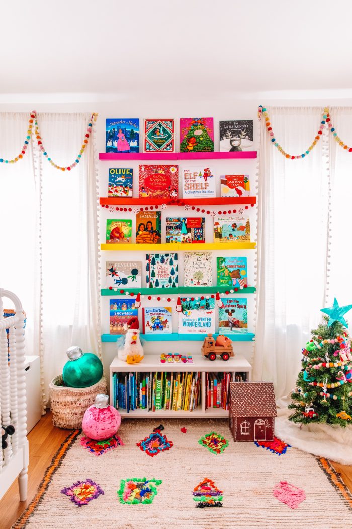 Photo of a child's room with a book self on the wall displaying Christmas books. 