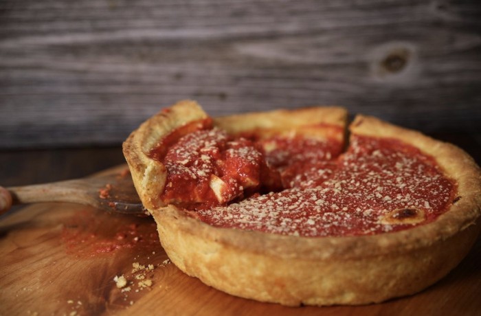 Hollywood Pies deep dish pizza with a slice being lifted out