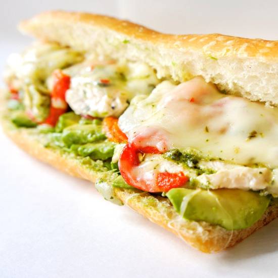 Honey cilantro lime chicken sandwich with avocado on a white background