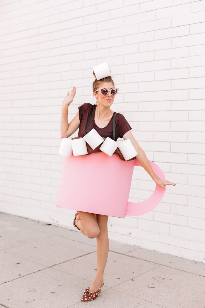 A woman standing in front of a building dressed as hot chocolate