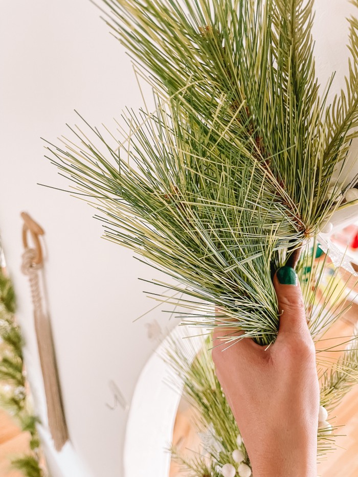 holding garland on wall