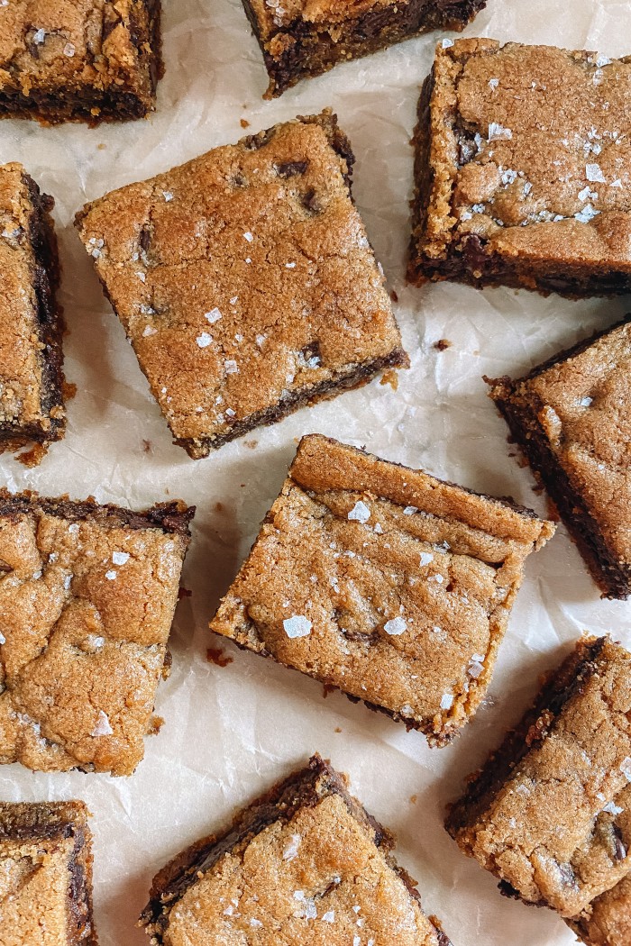 chocolate chip cookie bars on parchment paper with flaked salt on top