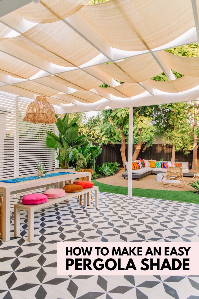 Backyard patio with patterned tile, long table and pergola with shade