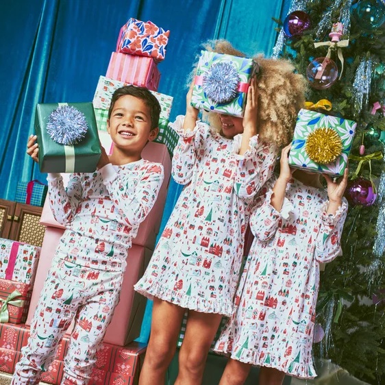 Kids with presents in christmas pajamas