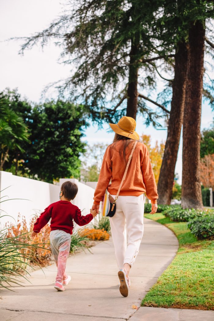 A boy and woman walking on a sidewalk