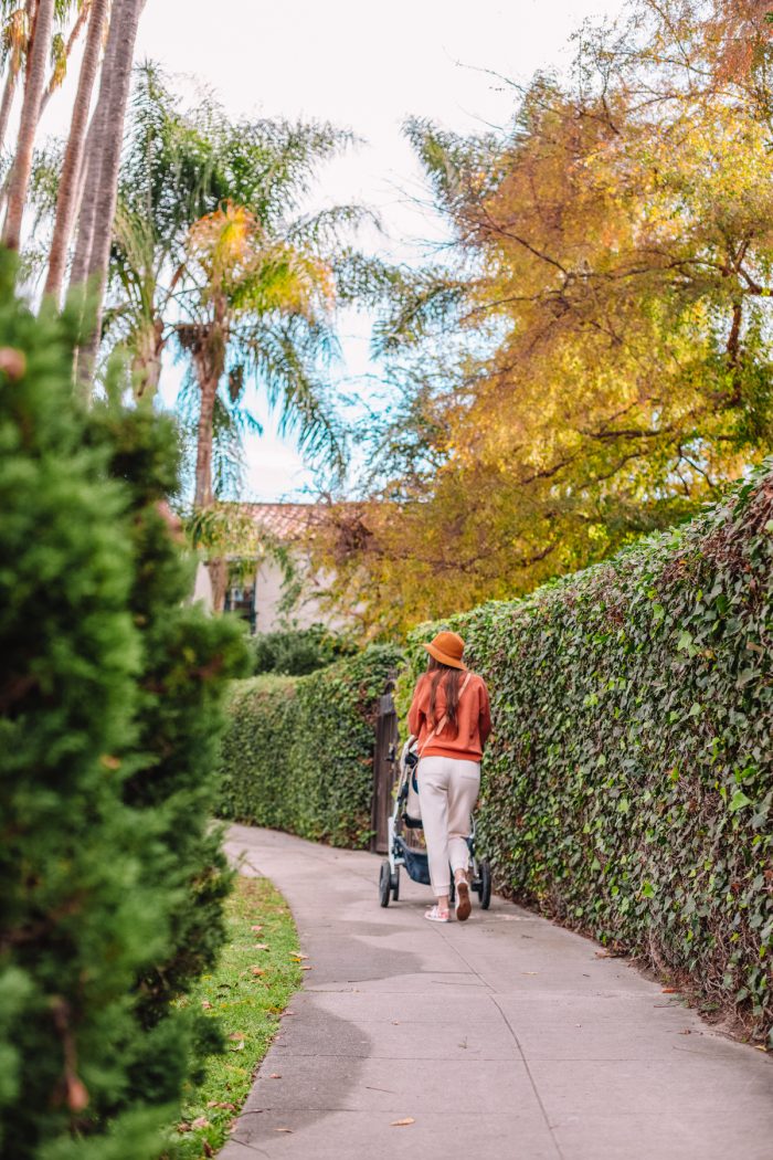 A person walking down a street with a stroller