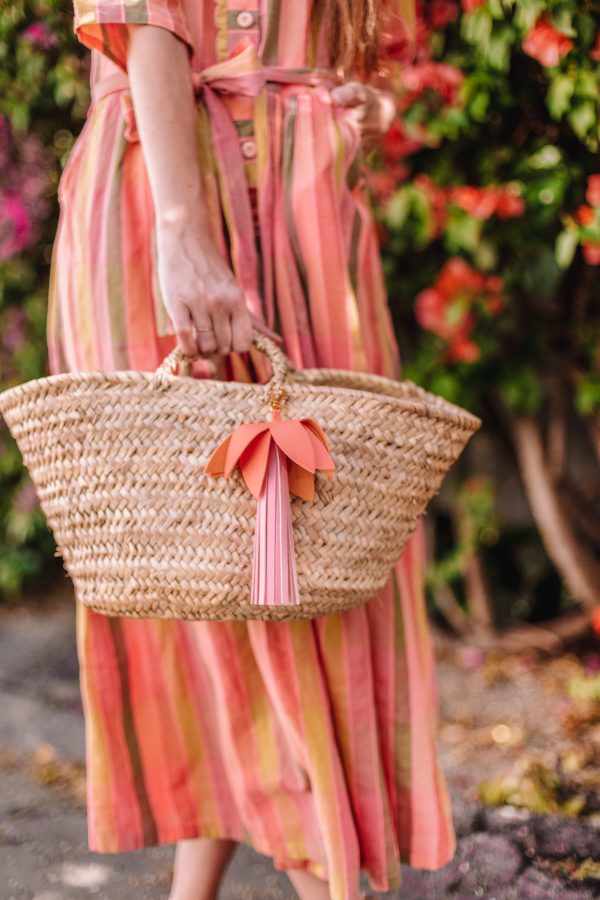 A woman wearing a pink dress holding a   basket