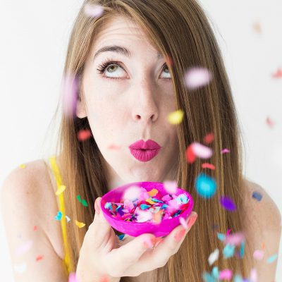 A woman holding a pink tray with confetti 