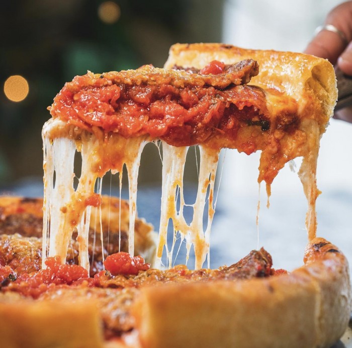 Masa of Echo Park slice of deep dish pizza being lifted up