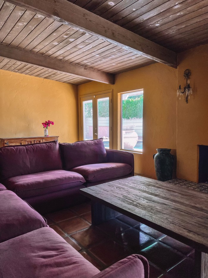 purple couch in ochre living room