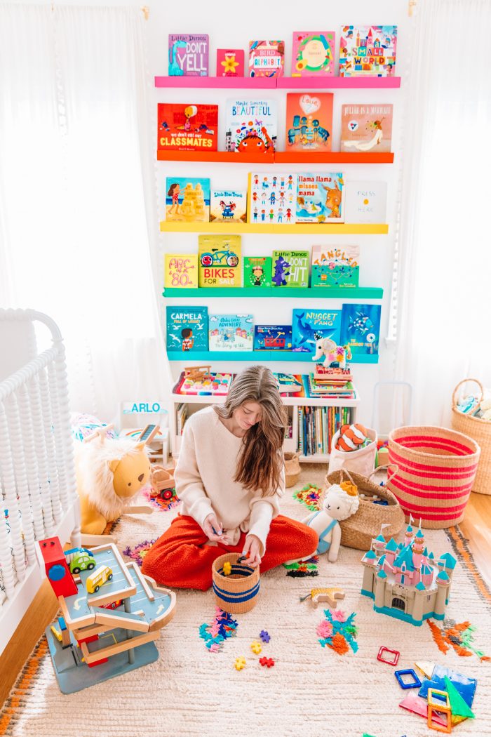 Someone sitting on the floor playing with toys