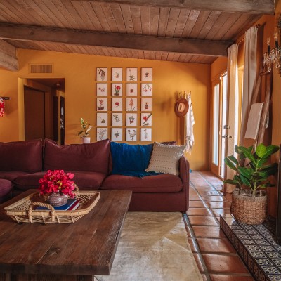 gallery wall behind purple couch in ochre living room