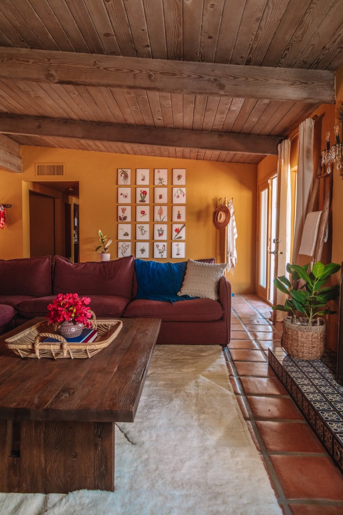 gallery wall behind purple couch in ochre living room