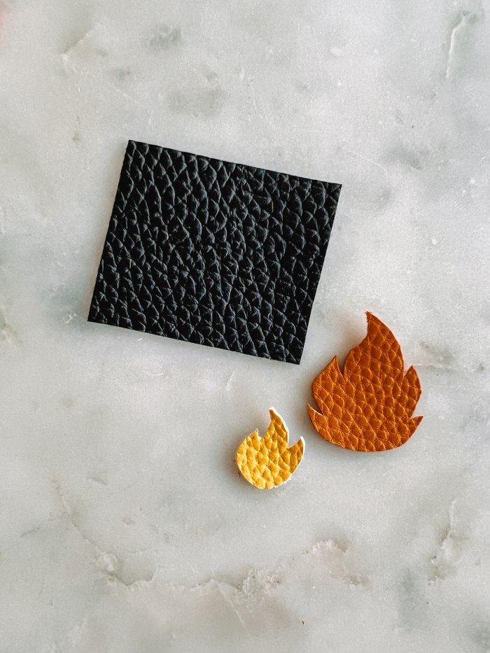 black rectangle and fire pieces cut out of leather on marble