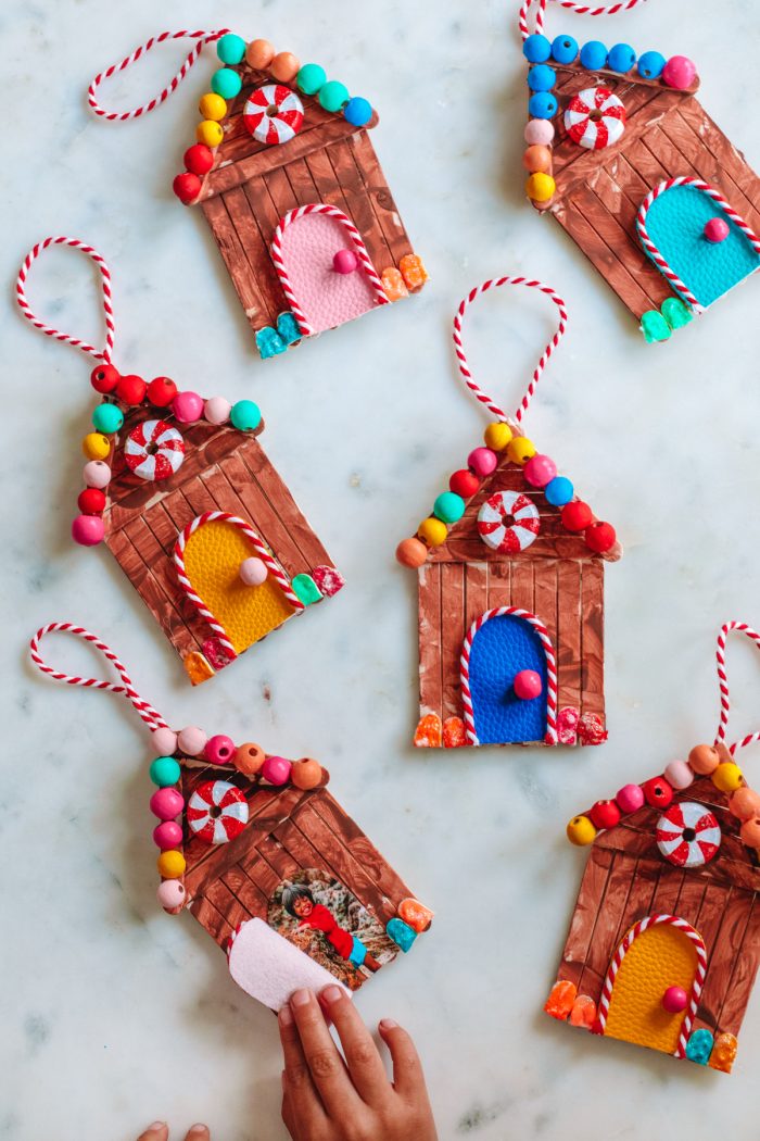 Overhead shot of gingerbread house ornaments on a marble background. 