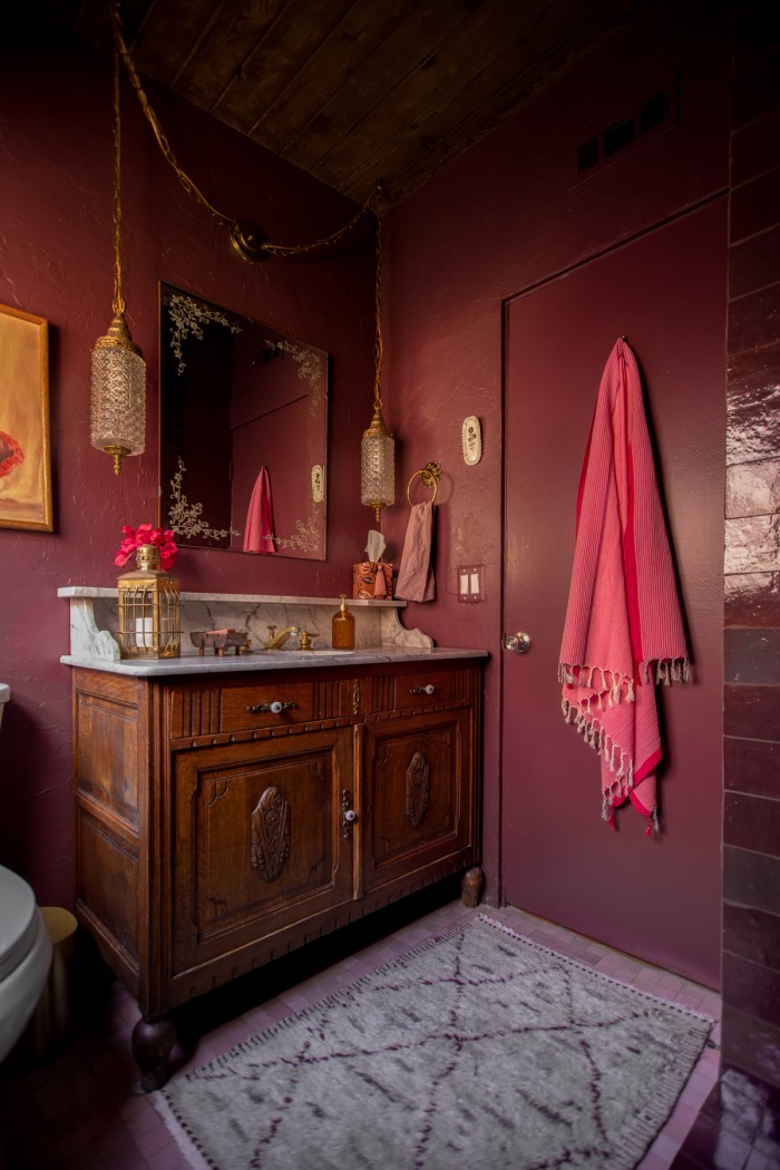 wood vanity with rug in front in purple bathroom