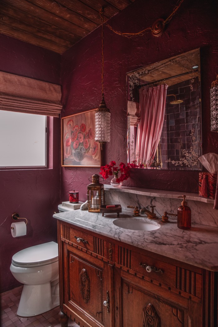 Plum bathroom with antique wood vanity