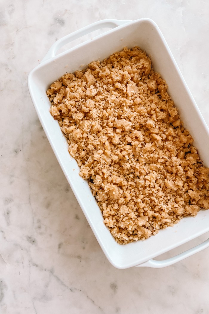 Raspberry bars with crumble on top in a white pan on a marble table