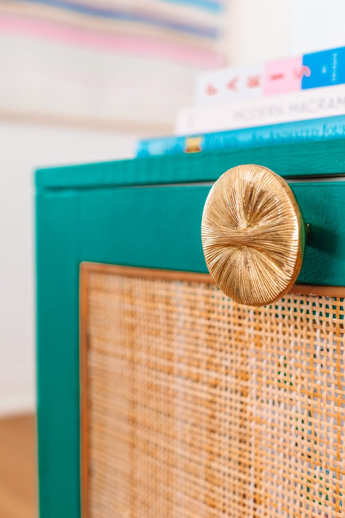 A close up of a turquoise cabinet with gold handle 