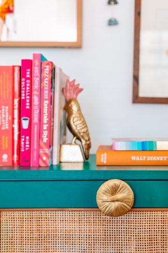 Colorful books on top of a dresser