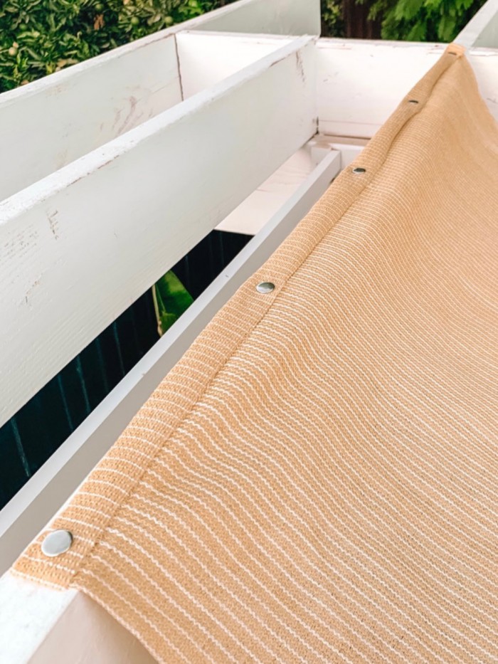 Patio sun shade snapped to beam of pergola