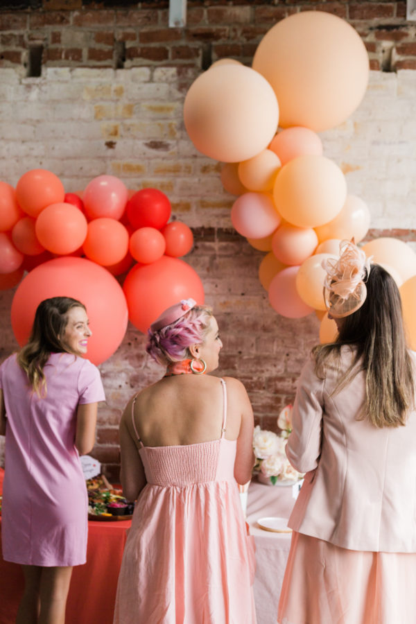 Three people standing in front of balloons