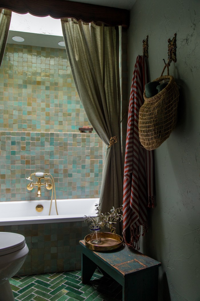 sage green bathroom with striped towel hanging on wall